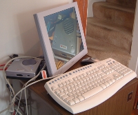 Tiny silver box next to big LCD and keyboard with lots of wires